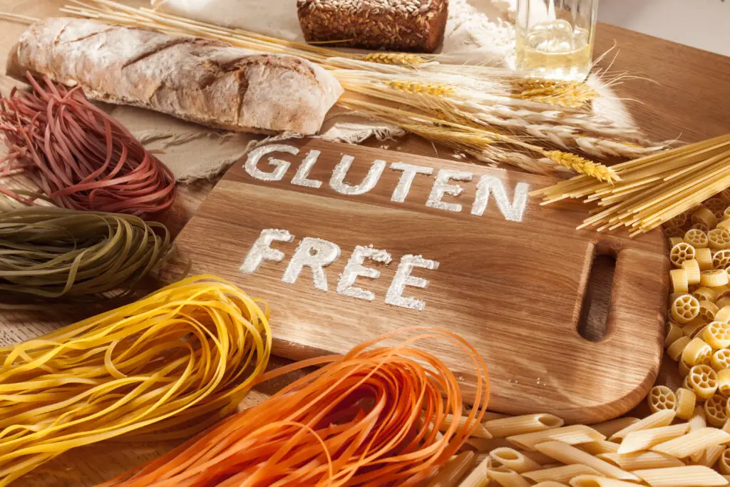 Gluten free food. Various pasta, bread and snacks on wooden background from top view